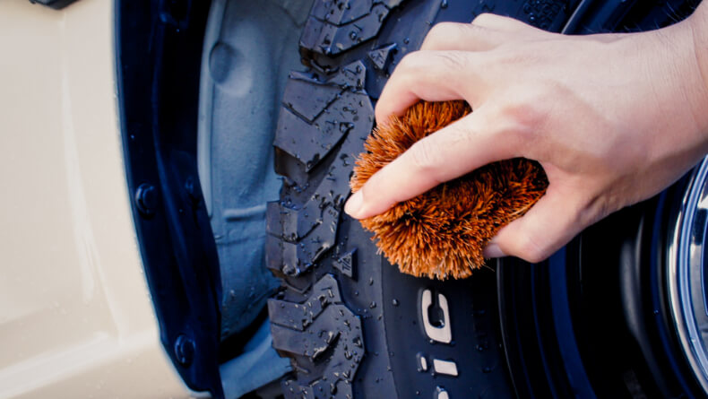 タイヤの汚れを水で洗い流しタワシで全体を磨きます